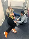 Ann-Sofie Franck-Ring skadet seg alvorlig under en pålagt trening på jobb i oktober 2023. Her venter hun med kollegaer på ambulansen. Foto: Privat