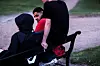 Moutasem Nahar snakker med jenta på benken. Ved siden av henne sitter kompisen.