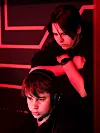 På Flame møter barn og unge voksne som ser dem og er opptatt av det samme som dem. Lena er trener i e-sport og er ansatt ved fritidsklubben gjennom idrettslaget.  Her instruerer hun Henrik.