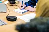 Foran sosionom og Nav-ansatt, Linda Bendiksen, ligger høyttaleren hun bruker til å kommunisere med telefontolken.