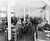 Lunsjpausa er et viktig avbrekk i arbeidshverdagen. Her fra spisesalen i velferdsanlegget på Herøya i Porsgrunn i 1956. På bordene kan man se kaffekrus, matpakker og enkelte som tar seg en sigarett i pausa.