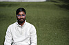 Shivaram Sivasubramaniam sitter på en grønn gressplen iført hvit genser og briller.