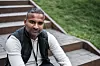 Sahayathasan Kaithampillai sitter i en utendørs trapp med grønne omgivelser.
