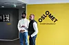 To menn foran OsloMet-logoen i en korridor ved universitetet.