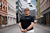 Person i svart T-skjorte står på en gate mellom bygårder under NAFs landsmøte 2023.